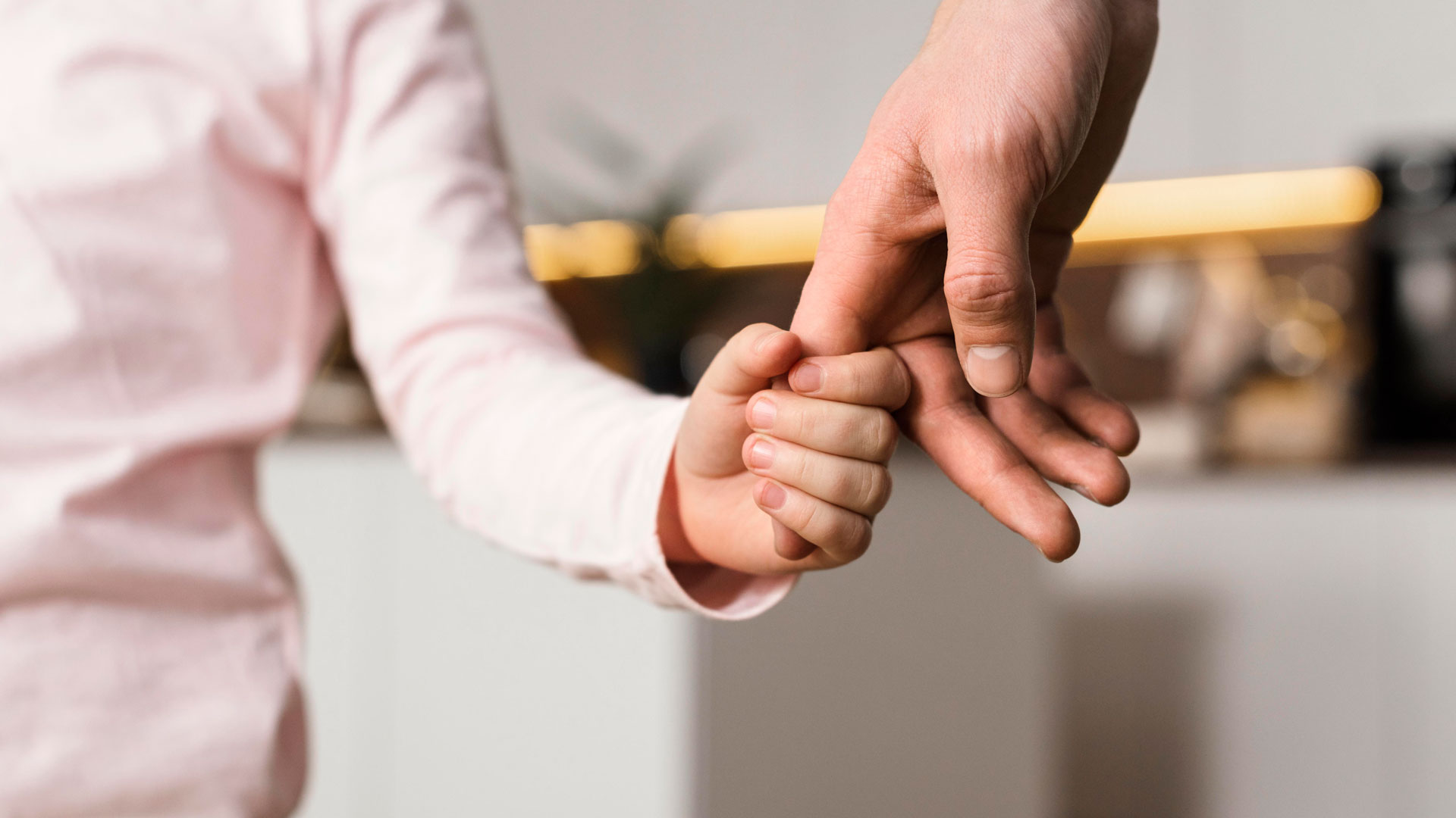 Child holding parent's finger